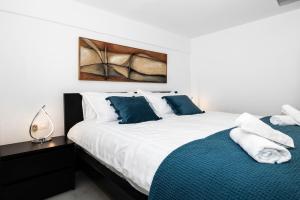 a bedroom with two beds with blue and white pillows at Maisonette near Heraklion Center Candia Maisonette in Heraklio Town