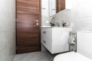 bagno con servizi igienici, lavandino e porta in legno di Maisonette near Heraklion Center Candia Maisonette a Heraklion