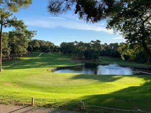 a golf course with a pond and a green at Océan Mobilhome Siblu Bonne Anse Village Vacances La Palmyre in Les Mathes