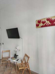 - un salon avec 2 chaises et une télévision murale dans l'établissement Affittacamere “La spezia “, à La Spezia