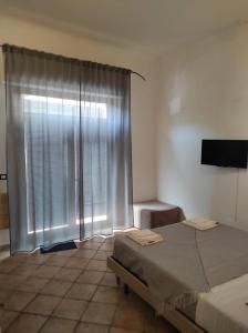 - une chambre avec un lit et une fenêtre avec des rideaux dans l'établissement Affittacamere “La spezia “, à La Spezia