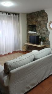 a living room with a couch and a tv at Pensión liebana in San Vicente de la Barquera