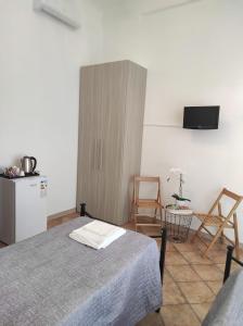 - une chambre avec un lit, un réfrigérateur et des chaises dans l'établissement Affittacamere “La spezia “, à La Spezia