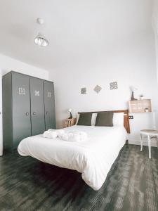 een slaapkamer met een groot bed met witte lakens bij El Segon Pis in Berga