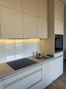 a kitchen with white cabinets and a sink at Apartament Nowa Cukrownia in Szczecin +9 photos