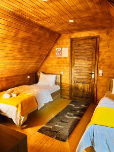 a bedroom with two beds in a wooden cabin at Sunshine House in Kutaisi