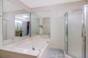 een witte badkamer met een bad en een douche bij Quality Inn Marietta in Marietta