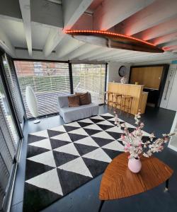 een woonkamer met een zwart-wit geruite vloer bij Tomorrowland loft poolhouse with pool in Willebroek