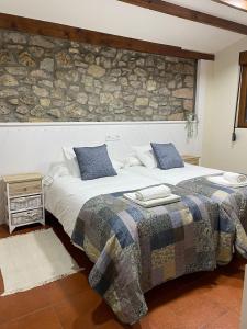 a bedroom with two beds and a stone wall at Pensión liebana in San Vicente de la Barquera