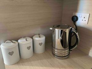 a tea kettle and three cups on a counter at The Beach Pad North Berwick in North Berwick
