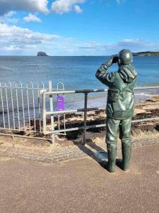 a statue of a man standing next to the ocean at The Beach Pad North Berwick in North Berwick