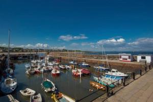 a bunch of boats are docked in a marina at The Beach Pad North Berwick in North Berwick