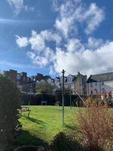a park with a bench in a field with houses at The Beach Pad North Berwick in North Berwick