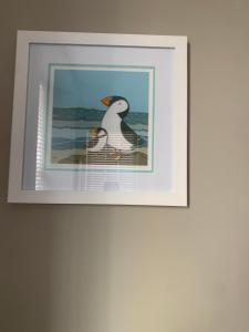 a framed picture of a bird on a wall at The Beach Pad North Berwick in North Berwick