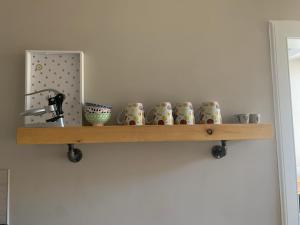 a shelf with cups on it on a wall at The Beach Pad North Berwick in North Berwick