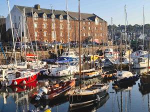 a group of boats docked in a marina with buildings at The Beach Pad North Berwick in North Berwick