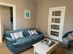a living room with a blue couch and a table at The Beach Pad North Berwick in North Berwick