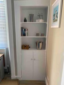 a white book shelf in a corner of a room at The Beach Pad North Berwick in North Berwick