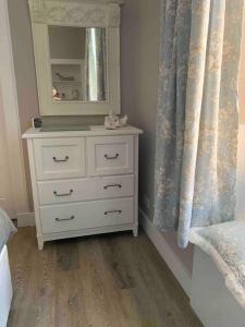 a bedroom with a white dresser and a mirror at The Beach Pad North Berwick in North Berwick