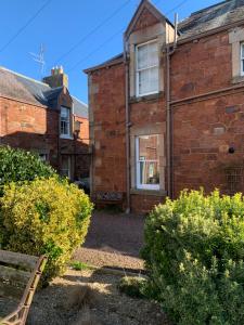 an old brick house with bushes in front of it at The Beach Pad North Berwick in North Berwick