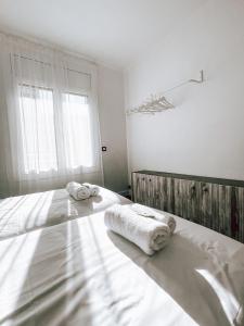 een witte slaapkamer met 2 handdoeken op een bed bij El Segon Pis in Berga