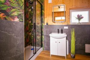 a bathroom with a sink and a shower at Nini House Swietajno in Olecko