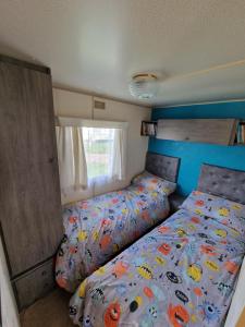 een kleine slaapkamer met een bed en een raam bij Hemsby Caravan Hire in Hemsby