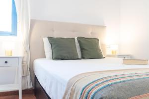 a bedroom with a bed with two green pillows at Villa Congrio in Las Negras