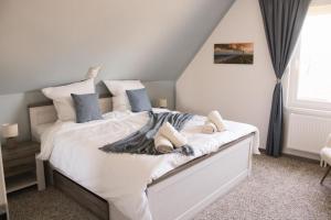 a bedroom with a bed with white sheets and blue pillows at Marica‘s Meereszeiten Wellness in Midlum