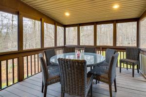 a screened in porch with a table and chairs at Hot Tub and Game Room Cozy Big Bass Lake Home! in Gouldsboro