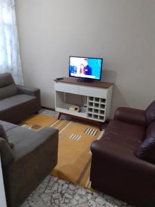 sala de estar con 2 sofás y TV de pantalla plana en 92SOLDAPRAIA Apto preparado para vc e sua familia, en Praia Grande
