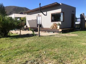 a tiny house with a porch in a yard at Casa de montaña in Potrerillos