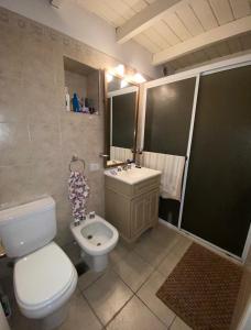 a bathroom with a white toilet and a sink at La Quinta de Pablo in Mercedes +18 photos