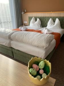 a hotel room with two beds and a basket of eggs at Várfal Wellness Panzió in Pécs