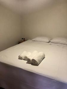 a bed with three rolled up towels on it at Kronemhouse Pousada in Petrópolis