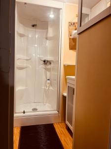 um chuveiro na casa de banho com uma cabina de duche branca em Mobil-home COSY clim&tv-3 Chambres em Vic-la-Gardiole