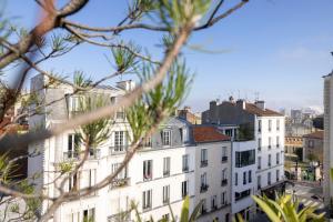 uma vista de um edifício por trás de algumas árvores em Maison Lavaud em Paris