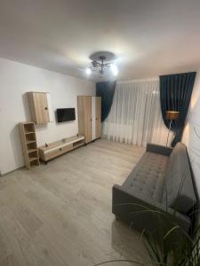 a living room with a couch and a flat screen tv at Apartament la Nicole ultracentral Bld Roman bloc 39 in Roman
