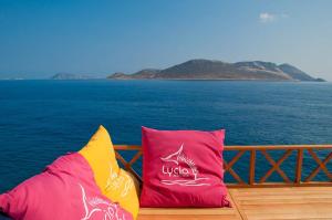 two colorful pillows sitting on a balcony overlooking the ocean at Lycia Hotel in Kaş