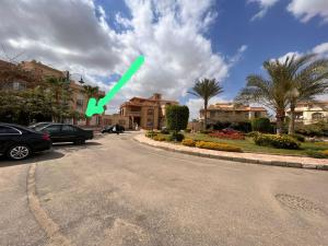 Una flecha verde apuntando por un camino con casas en New cairo apartment in front of Garden 8 Mall en El Cairo