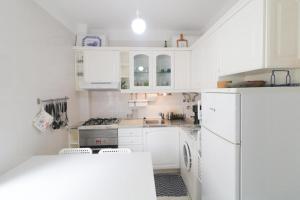 - une cuisine blanche avec des placards blancs et une cuisinière dans l'établissement Mar Azul, à Praia da Barra