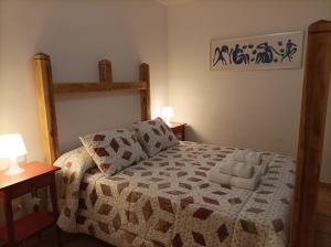 テルエルにあるCasa rural El Pitañarのベッドルーム1室(ベッド1台、ナイトスタンド2つ、ランプ2つ付)