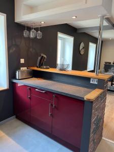 una cucina con armadi rossi e piano di lavoro di 36 avenue de la gare a Concarneau