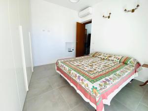 a bedroom with a bed with a colorful blanket on it at La Stella Marinella in Santa Marinella