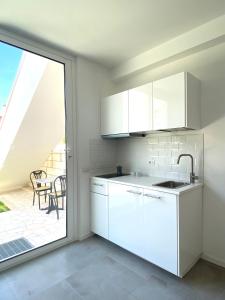 a kitchen with white cabinets and a large window at La Stella Marinella in Santa Marinella