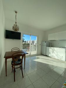 a dining room with a table and a kitchen at La Stella Marinella in Santa Marinella