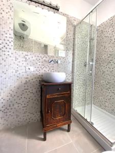 een badkamer met een wastafel en een glazen douche bij La Stella Marinella in Santa Marinella