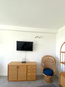 een kamer met een tv aan de muur met een stoel bij La Stella Marinella in Santa Marinella