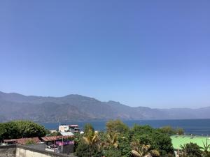 Blick auf das Wasser und die Berge aus einer Stadt in der Unterkunft CASA BATZ #1 in San Pedro La Laguna