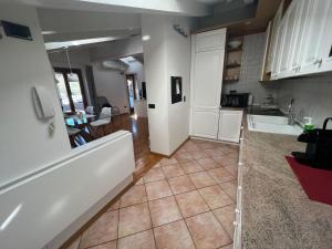 a kitchen with white cabinets and a tile floor at Ai Cappuccini, Trento a 360 gradi in Trento
